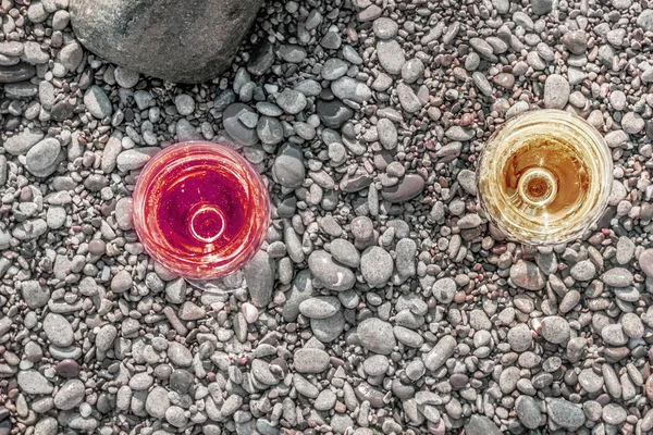 两杯迷人的白葡萄酒和红酒在海卵石上 — 图库照片