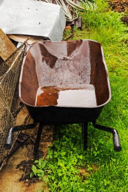Büyük kahverengi eski metal bahçe el arabası yaz gününde