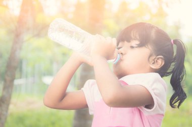 Asyalı küçük kız içme suyu ormanda