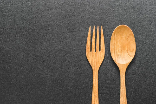 木制叉子和勺子在黑桌上 顶部看法 — 图库照片