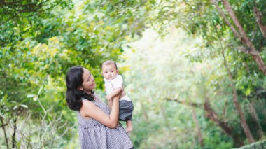 Anne Çocuk yaz Park, Sevimli Asya bebek çocuk taşır.