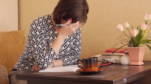 Μια γυναίκα γράφει χειρόγραφου κειμένου με ένα στυλό σε ένα σημειωματάριο. — Αρχείο Βίντεο