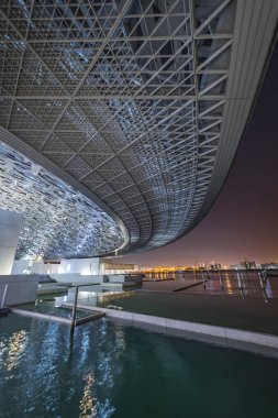 Louvre, Abu Dhabi, Birleşik Arap Emirlikleri - Dec.29, 2017: Kubbe kanat manzaralı bir şehir ışıkları altında gece müzede takımlık