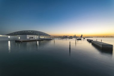 Denizden şehir günbatımı. Louvre Müzesi, Abu Dhabi, b. a. Emirlikleri, Dec.2017 kapatın