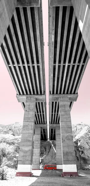 Wadi Karayolu Köprüsü altında kırmızı otobüs. Dichromatic