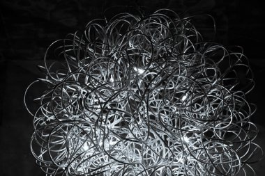 Kavisli gümüş tel avize closeup. Modern metal abajur. Siyah ve beyaz soyut dokulu arka plan. Soyut kaotik desen. Fütüristik soyut fon. İç dekorasyon. Çağdaş iç aydınlatma lambası. Geometrik çizgi tel topu.