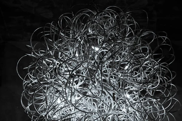 Kavisli gümüş tel avize closeup. Modern metal abajur. Siyah ve beyaz soyut dokulu arka plan. Soyut kaotik desen. Fütüristik soyut fon. İç dekorasyon. Çağdaş iç aydınlatma lambası. Geometrik çizgi tel topu.