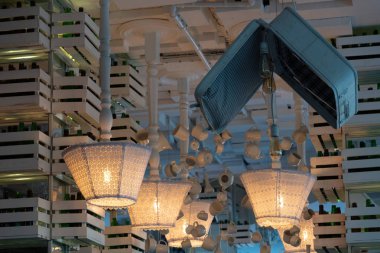 Tavana monte dantel tekstil abajurlar ile eski baş aşağı zemin lambaları Satırlar. Oyma ahşap bacaklı standart lambalar. Açık eski moda bavul ve çizgili arka plan ile Retro tarzı dekor. Rustik tarzı aydınlatma. Beyaz renkli iç.