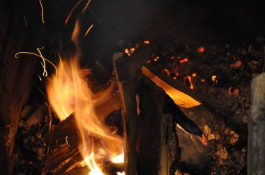 Bulanık alev hareketi soyut arka plan kıvılcım izleri ile. Odun ateşi karanlıkta yanıyor. Yanan közlerle kamp ateşi yakmak. Soyut yangın sıçramaları. Parlak yanan doku