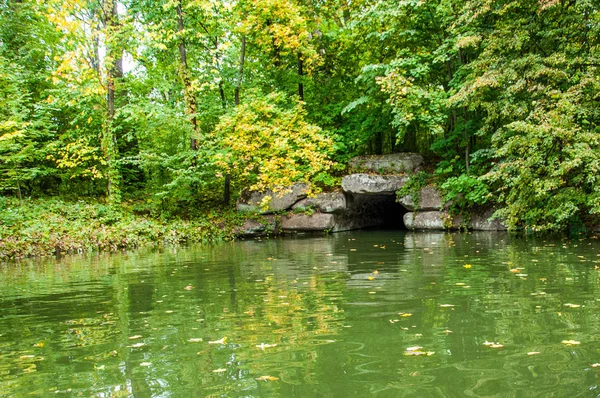 湖面上的古石洞 黄树叶落入平静的水中 池塘水中的反射 乌克兰乌曼乌曼的萨维伊夫卡国家公园风景 萨维耶夫卡乌曼公园和平秋天场景 — 图库照片