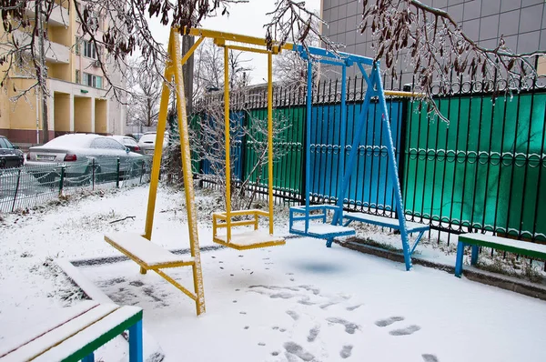 Желтые Синие Дети Качели Покрыты Белым Снегом Детской Площадке Следы — стоковое фото