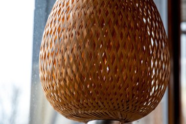 Hasır saman abajur yakın plan. Doğal çapraz saman örgü dokusu ve arka ışıklandırma. Şekillendirilmiş kafes lambası. Açık bej şebeke modeli. Geometrik şekiller ve çizgiler soyut arkaplan. 3D şekiller 