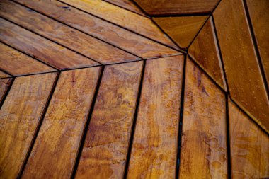 Yağmur sonrası su damlaları ile kahverengi ahşap plakalar cilalı yüzeyi. Çizgili ahşap arka plan. Ahşap panoları geometrik deseni. Islak vernikli ahşap doku çekim.
