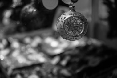 Bokeh bulanık arka plan üzerinde ışıltılı cam topu Noel süsü closeup asılı odak ile siyah ve beyaz fotoğraf. Tatil özniteliği. Noel havası. Yeni Yıl dekorasyonu.
