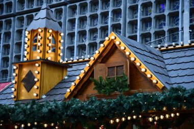 Ahşap çatı kozalaklı şube çelenk ve retro tarzı cam ampuller altın Noel ışıkları ile dekore edilmiştir. Berlin Almanya'daki Noel fuarında kuleli rustik pavyonun yeni yıl aydınlatmaları