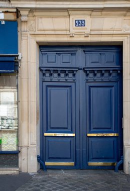 Elegat lacivert Paris Fransa'da eski binanın antikçerçeveli kapı boyalı. Mat boyalı ahşap kapı panelleri ve parlak parlak altın metal plakalar onun. Antik taş evin vintage kapı