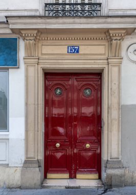 Paris Fransa'da evin antika süslü kırmızı kapı yanları tarafından sütunlar ile heykel kemer içinde klasik mimari kapı. Altın kapı toklukları ile bordo renkli parlak boya ahşap çift kapı