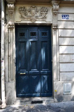 Paris / Fransa - 06 26 2019: Avrupa'da eski binanın koyu mavi boyalı antikçerçeveli kapı üzerinde muhteşem süslü taş fretwork. Barok mimari ön kapı