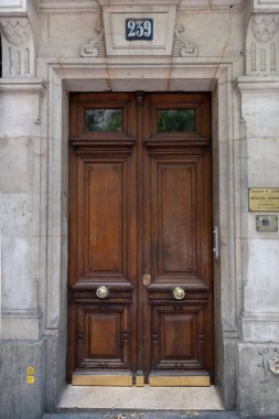 Paris / Fransa - 06 26 2019: Vintage numarası 239 altında eski ahşap kapı. Avrupa'da eski binanın koyu ahşap çift kapı girişi. Altın parlak metal kapı toklukları ve kirli taş duvarlar ile antik kapı