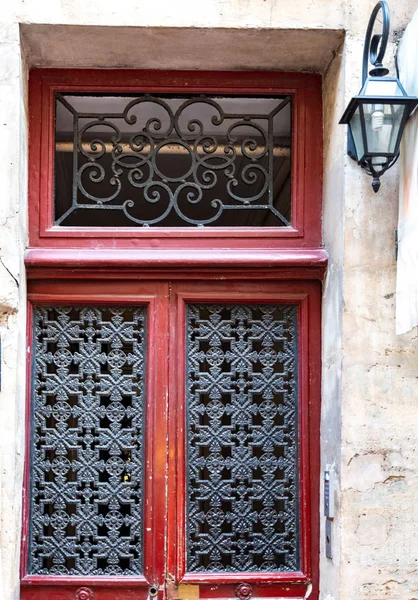 Rote Schäbige Holztür Mit Vintage Verzierten Schwarzen Metallgittern Den Türfenstern — Stockfoto