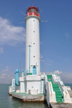 Güneşli bir günde deniz kenarında deniz feneri