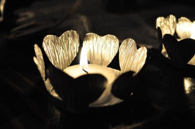 Karanlık arka planda kalpleri olan parlak mumlar.