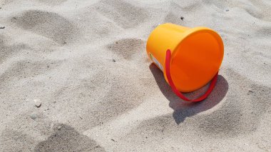 Kumsalda turuncu plastik sepet