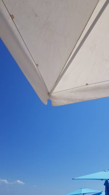 Renkli şemsiyeler ve mavi gökyüzü ile tatil havası
