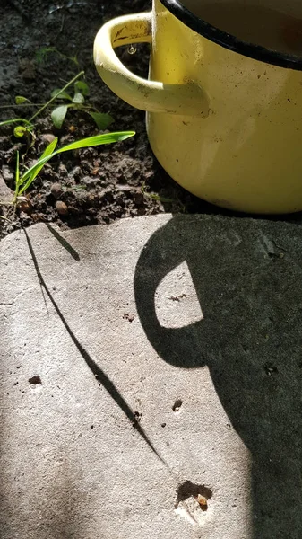 Gelber Emaille Becher Auf Dem Gartenboden — Stockfoto