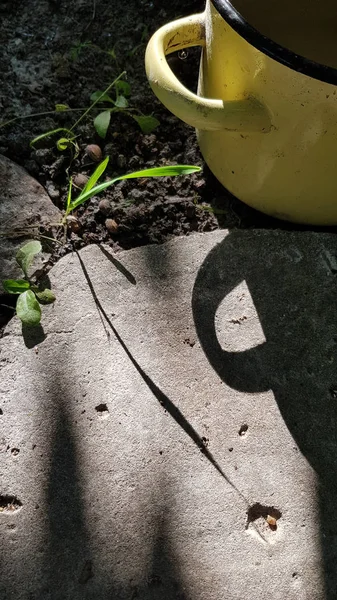 Gelber Emaille Becher Auf Dem Gartenboden — Stockfoto