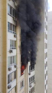 Binanın pencerelerinden siyah dumanlar yükseliyor. Protestolarda kundaklama sonucu kaza.