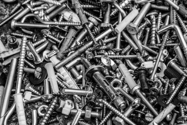 Birçok metal cıvata ve fındık düz yatıyordu monokrom filtre fotoğraf. Çalışma araçları yakın çekim. Babalar Günü için soyut endüstriyel geçmiş