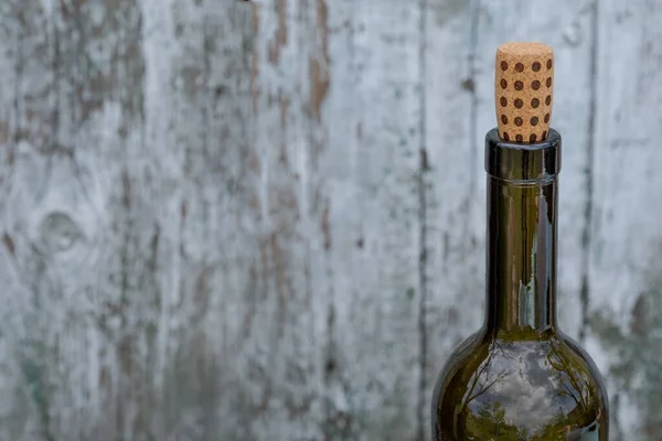 緑のガラスのボトルの上に点在するワインコルクは 負のスペースで白い悩んでいる木の背景に焦点を当てています ワインの試飲コンセプト — ストック写真
