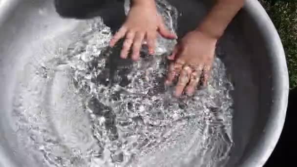 Kid washing hands in clear water inside basin. Summer fun — Stock Video