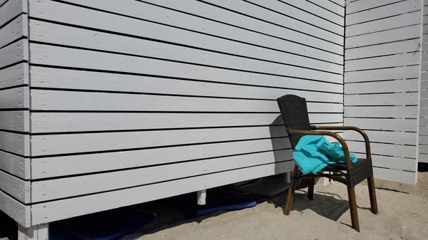 拉坦椅子与皱折的蓝色毯子在白色油漆木墙背景与复制空间 干净沙滩上海滨避暑别墅的条纹木板墙 — 图库照片