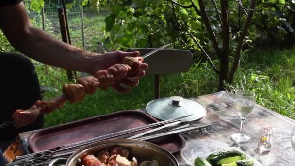 Manos masculinas tomar carne cruda shish kebab y ponerlo en brochetas de metal — Vídeos de Stock