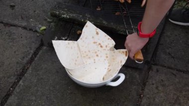 Barbeküde ızgara sosis hazırlığı var. Geleneksel Alman ızgara sosisleri pide ekmeğine sarılmış olarak kaseye kapatılır. Ev yapımı Münih sosisleri yakın plan.