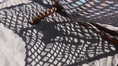 Sallanan hamağın bulanık gölgeleri ve kumsaldaki çocuk silueti