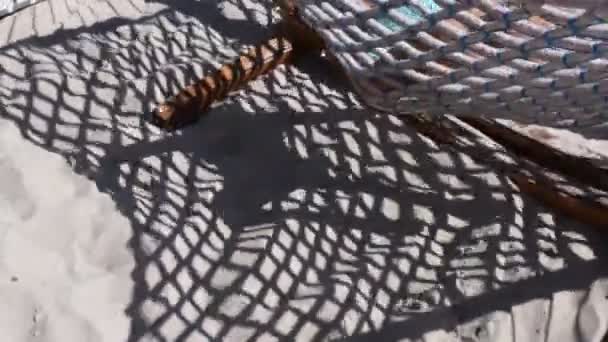 Sombras desfocadas de rede balançando rede e criança silhueta na areia da praia — Vídeo de Stock