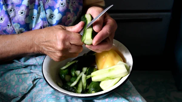 할머니의 오이를 껍질을 벗기고 조각나게 부엌에서 음식을 준비하고 여성의 — 스톡 사진