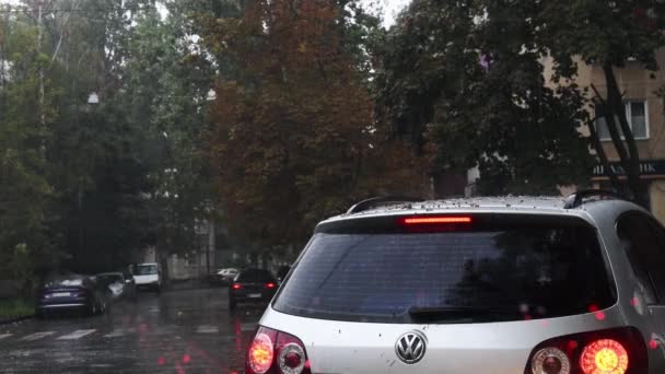 Şiddetli yağmur yağarken nemli ön camdan dışarı odaklanmış görüntü. Sonbaharda sağanak yağmurda araba sürmek — Stok video