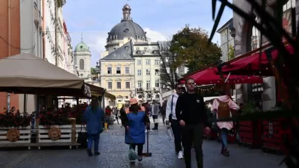 Time lapse menigte van toeristen lopen door Lviv straat met uitzicht op Rynok plein en Dominicaanse kathedraal koepel — Stockvideo