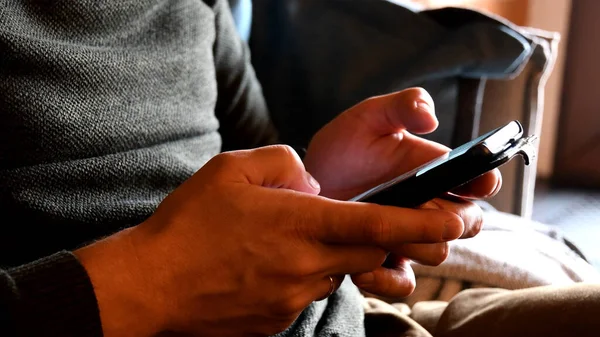 Male hands hold cell phone tapping and browsing internet on smartphone. Closeup mobile phone using. Technology communication concept