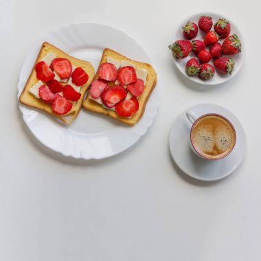 Beyaz arka plan üzerinde çilek sandviç kahvaltı. Siyah kahve ve çilek.