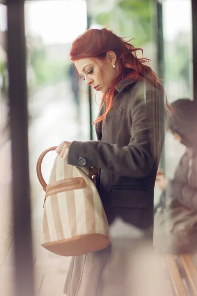 Schöne Junge Frau Wartet Einer Bushaltestelle Und Schaut Ihre Handtasche — Stockfoto