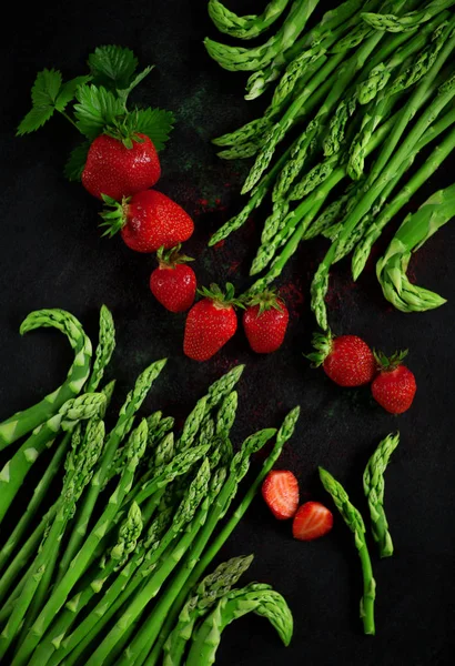 딸기와 신선한 아스파라거스 어두운 접시에 사용할 배경으로 — 스톡 사진
