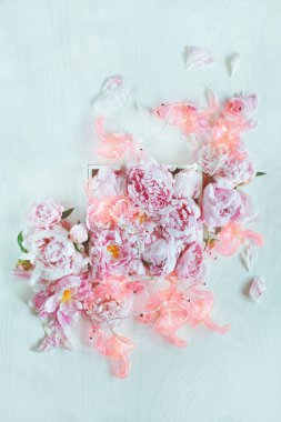 Beyaz ahşap masa ışıkları, komik flamingo zinciri ile dekore edilmiş güzel pembe, gül peonies arka plan olarak kullanılabilir