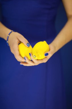 Mükemmel ile güzel kadın el cilası limon holding, mavi meyve sarı, arka plan olarak kullanılabilir
