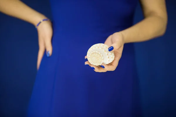 Schöne Frauenhände Mit Perfektem Nagellack Der Kleine Schneckenhäuser Vor Blauem — Stockfoto