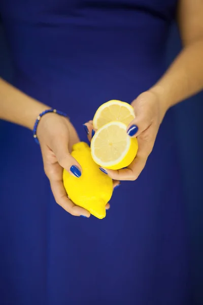 完璧で美しい女性手マニキュア レモンを保持 青の果実を黄色 背景として使用することができます — ストック写真